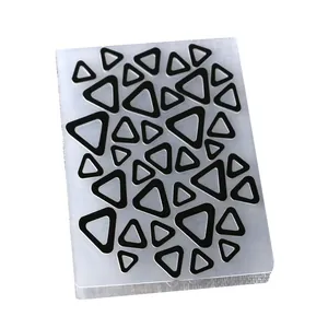 Detailed view of DIY plastic embossing folder with geometric triangle pattern for scrapbooking.