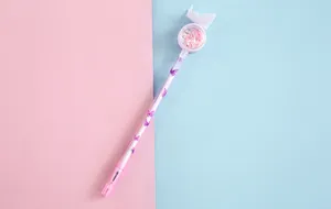 Detailed view of a cute pink butterfly gel pen featuring heart-shaped sequins in a clear capsule
