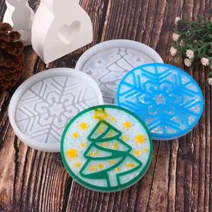 Detail view of Christmas tree and snowflake silicone molds with finished resin coasters.