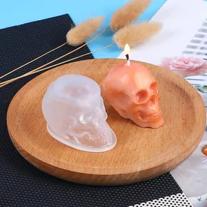Macro detailed view of a skull silicone mold and a finished orange lit candle display.