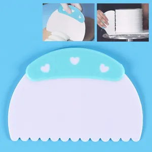 Detalle de rasqueta de plástico para pasteles con mango de corazón azul para repostería