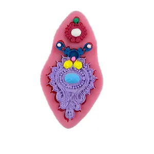 Détail des motifs en relief baroques sur le moule à fondant en silicone rose pour gâteaux