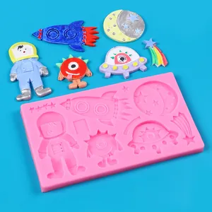 Detailed macro view of pink space-themed silicone mold with finished colorful alien crafts