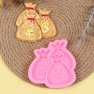 Pink silicone mold and golden money bags with dollar and yen symbols for DIY cake decorating