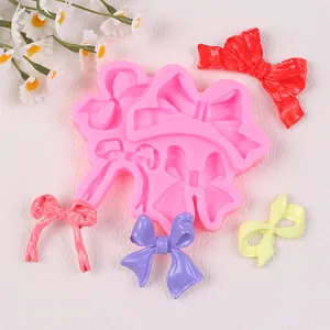 Molde de silicona rosa para lazos con decoraciones de pastel coloridas terminadas