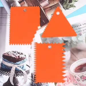 Macro view of three orange plastic serrated cake scrapers for professional DIY baking decoration