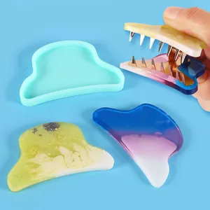 Detail of DIY silicone mold showing finished resin hair clip accessories with glitter.