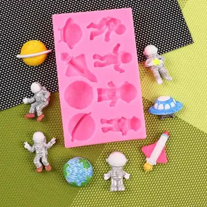 Pink silicone space astronaut and rocket mold showing finished fondant cake toppers