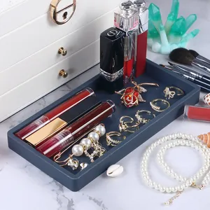 Detailed view of dark blue silicone tray organizing jewelry and cosmetics on marble