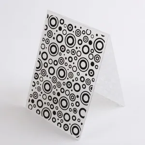 Close-up detail of a DIY plastic embossing folder featuring a black circle pattern design