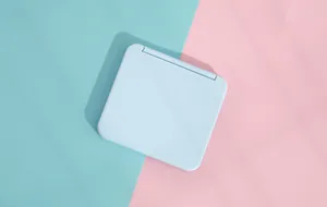 Detail view of a compact pastel blue portable makeup mirror on candy-colored background