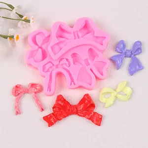 Detalle del molde de silicona rosa con varias formas de lazos para decoraciones DIY