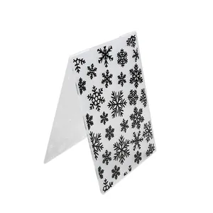 Acrylic embossing folder with black snowflake patterns for paper crafting and drawing