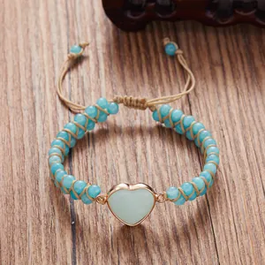 Vista detallada de una pulsera trenzada a mano con piedra en forma de corazón y cuentas azules.