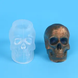 Detailed view of translucent skull silicone mold and a finished bronze resin skull ornament