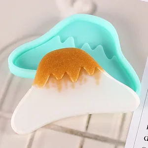 Close-up of Fuji mountain silicone mold and bicolored resin piece for DIY hair accessories.