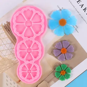 Detailed view of a pink sunflower silicone mold showing three sizes of resin flowers
