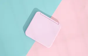 Detailed close-up of a pink portable folding makeup mirror in aesthetic candy colors