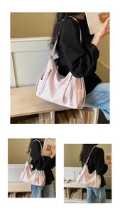Close-up of a pink large capacity hobo shoulder bag worn by a model in an indoor setting