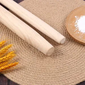 Primer plano de rodillos de madera de haya natural sobre un tapete de cocina tejido.