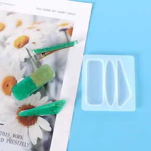 Vue détaillée d'un moule à épingles en silicone avec des pinces à cheveux en résine verte