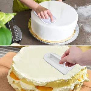 Detailed view of a professional white plastic cake smoother being used on a fresh cream cake