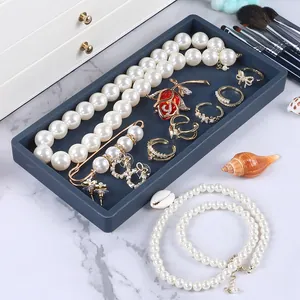 Close-up detail view of dark grey silicone jewelry organizer tray on marble surface