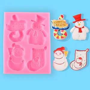 Close-up of pink Christmas silicone mold featuring snowman and stocking designs with finished crafts