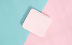 Macro view of portable light pink square folding makeup mirror on pastel background