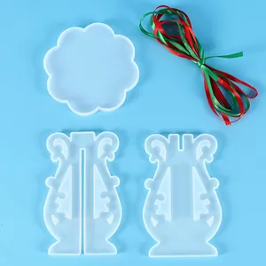 Detail view of three clear silicone resin molds and a bundle of red and green ribbons.