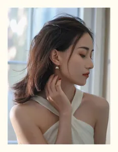 Elegantes pendientes de perlas de agua dulce en forma de racimo en la oreja de modelo