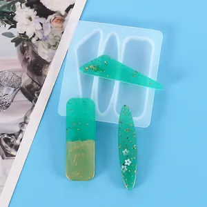 Vue détaillée du moule en silicone pour barrettes DIY avec clips en résine vert et or.