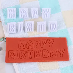 Detail van lettervormpjes voor fondant met Happy Birthday-afdruk op het deeg