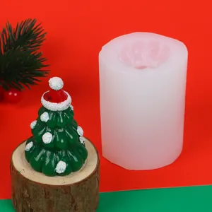 Detail view of white silicone mold next to finished Christmas tree candle on wood base.