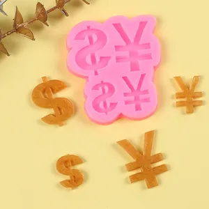 Detailed view of pink silicone mold with currency symbols and golden glittery finished crafts.