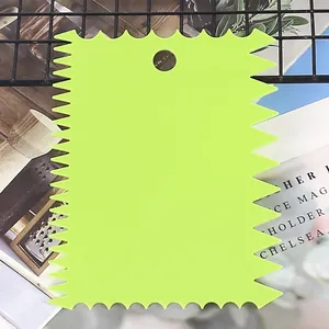 Macro view of a lime green serrated plastic cake scraper tool with a practical hanging hole.
