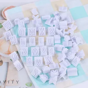 Gedetailleerd overzicht van witte letter- en symboolstempels voor koekjesdecoratie.