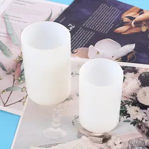 Close-up view of two translucent cylindrical silicone molds for DIY resin crafts and candle making.