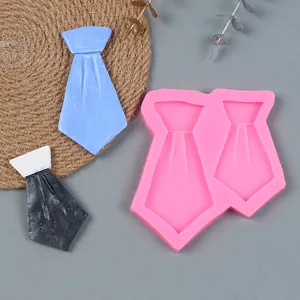 Roze siliconen stropdas mal met afgewerkte blauwe en zwarte fondant monsters