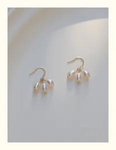 Detalle de pendientes rellenos de oro de 14K con racimos de perlas de agua dulce