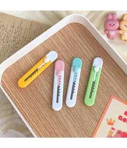 Detailed view of four colorful mini utility knives for box opening in a wooden tray