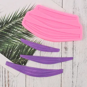 Close-up view of a pink silicone lace mold showing detailed texture and finished purple fondant strips