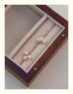 Detalle de cerca de pendientes de perlas de agua dulce en forma de racimo en una caja de madera