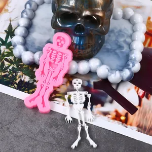 Detailed macro shot of pink Halloween skeleton silicone mold and finished white resin figure
