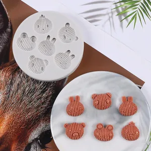 Detail view of animal-shaped silicone mold with finished brown chocolate pieces on plate