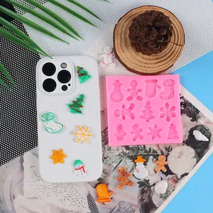 Detailansicht einer Weihnachts-Silikonform und fertigen Harzanhängern für DIY-Handyhüllen