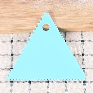 Detail view of a light blue plastic triangular serrated scraper for cake DIY baking projects
