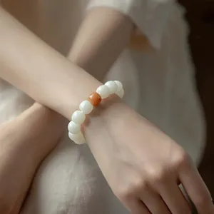 Eleganter weißer Jade-Stil Perlenarmband mit orangefarbenem Akzent am Handgelenk