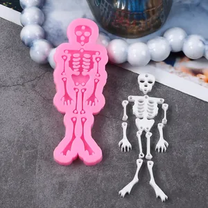 Detail showing pink Halloween skeleton silicone mold and finished white resin pieces.