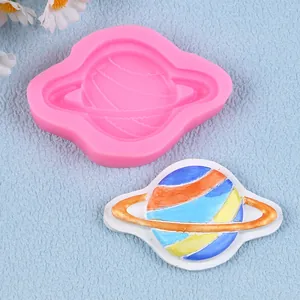 Detailed view of pink Saturn silicone mold and a colorful finished clay planet craft